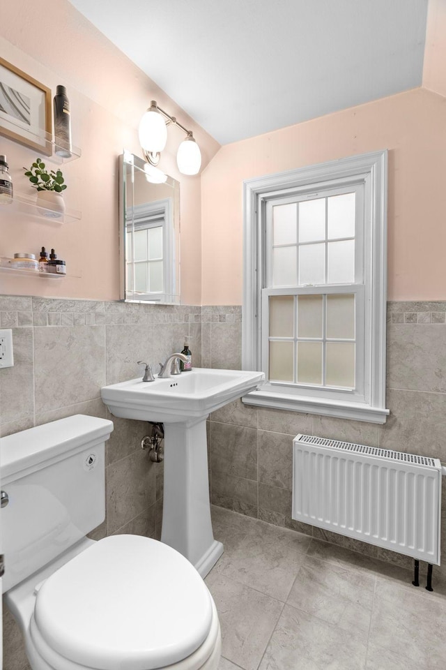 1921 James Ave, Saint Paul, MN 55105 - bathroom featuring radiator, tile walls, wainscoting, tile patterned floors, and lofted ceiling