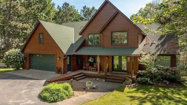 49760 202nd Pl, Mcgregor, MN 55760 - rustic home with covered porch, roof with shingles, an attached garage, concrete driveway, and a front lawn
