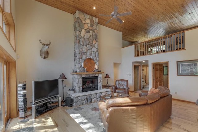49760 202nd Pl, Mcgregor, MN 55760 - living room featuring a high ceiling, light wood finished floors, a ceiling fan, a stone fireplace, and wood ceiling