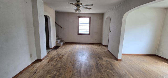 922 White St, Jackson, MN 56143 - unfurnished room with arched walkways, a ceiling fan, wood finished floors, and stairs
