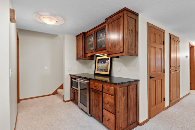 842 Vista Cir, Delano, MN 55328 - kitchen with light colored carpet, wine cooler, stainless steel microwave, glass insert cabinets, and brown cabinets