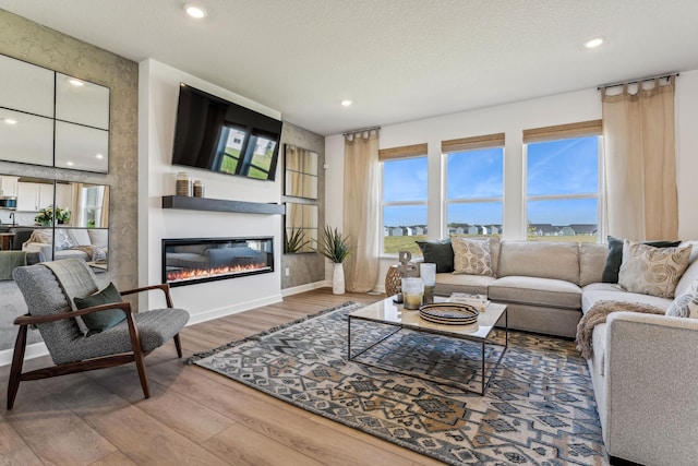 7588 Norway Ln, Lino Lakes, MN 55038 - living area featuring wood finished floors, recessed lighting, and a glass covered fireplace