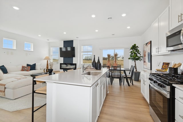 6265 205th St N, Forest Lake, MN 55025 - kitchen featuring stainless steel appliances, open floor plan, a breakfast bar area, recessed lighting, and light wood finished floors