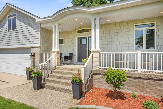 70348 219th St, Dassel, MN 55325 - doorway to property featuring covered porch, concrete driveway, and an attached garage