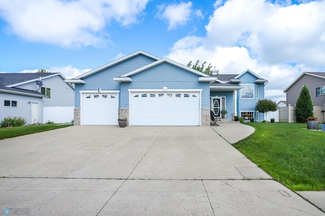 4450 48th St S, Fargo, ND 58104 - view of front of house featuring a garage, driveway, a front yard, and stone siding