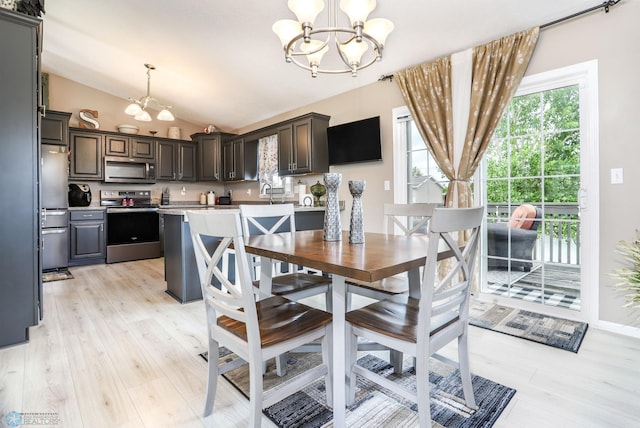 4450 48th St S, Fargo, ND 58104 - dining area featuring a chandelier, vaulted ceiling, and light wood finished floors
