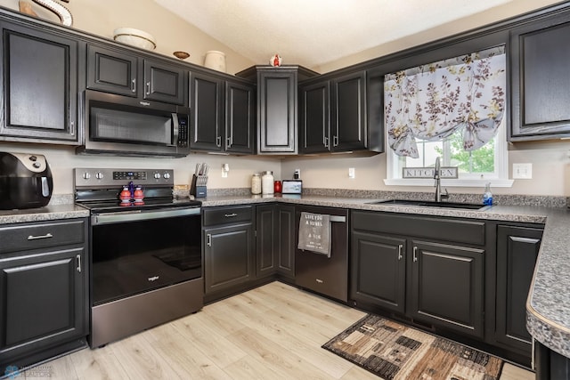 4450 48th St S, Fargo, ND 58104 - kitchen with stainless steel range with electric cooktop, dishwashing machine, light wood-style flooring, and dark cabinets