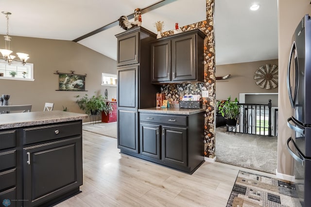 4450 48th St S, Fargo, ND 58104 - kitchen with vaulted ceiling, a chandelier, freestanding refrigerator, light wood-style floors, and tasteful backsplash