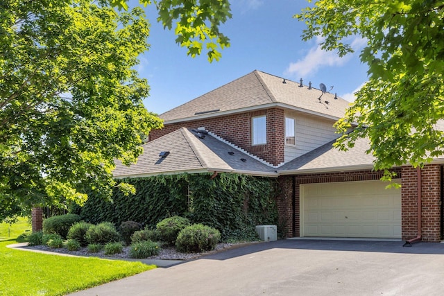 1900 Hunter Hill Rd, Hudson, WI 54016 - view of front of house with roof with shingles, asphalt driveway, a garage, and brick siding