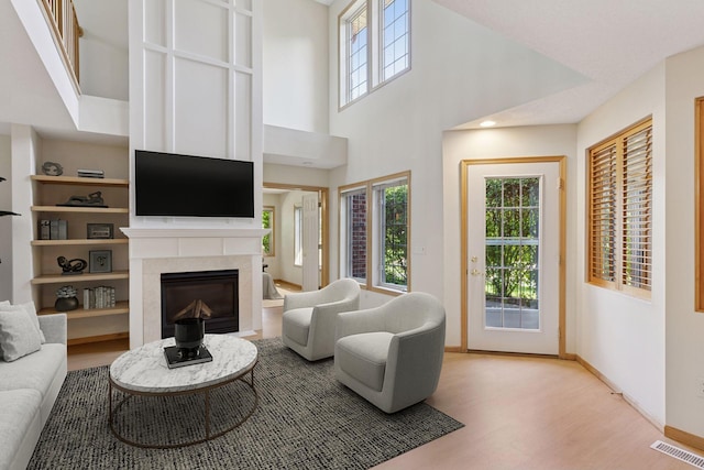 1900 Hunter Hill Rd, Hudson, WI 54016 - living room featuring wood finished floors, a glass covered fireplace, and a high ceiling