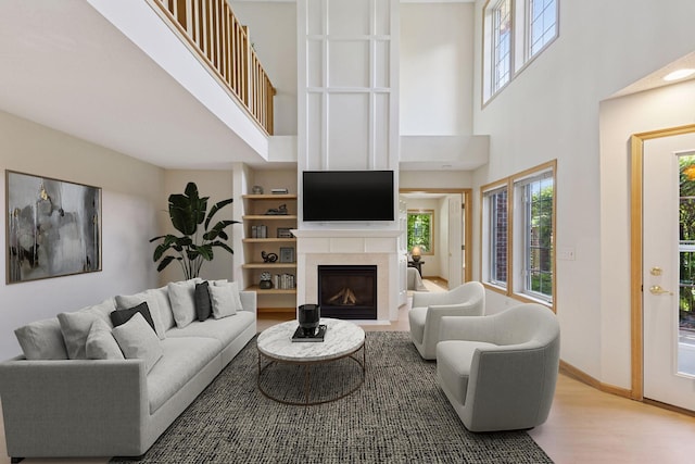 1900 Hunter Hill Rd, Hudson, WI 54016 - living room with a towering ceiling, wood finished floors, healthy amount of natural light, and a glass covered fireplace
