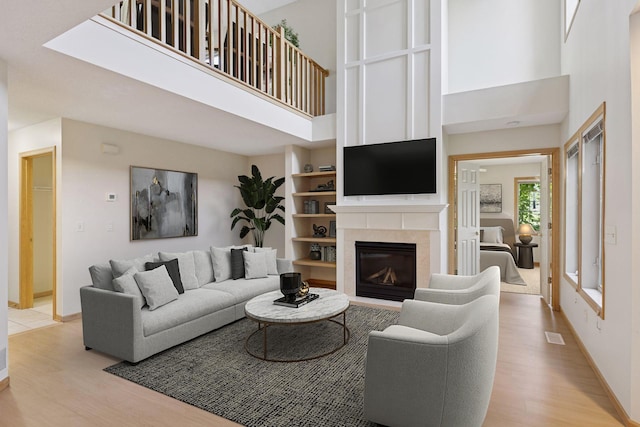 1900 Hunter Hill Rd, Hudson, WI 54016 - living area with a high ceiling, light wood finished floors, and a glass covered fireplace