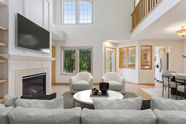 1900 Hunter Hill Rd, Hudson, WI 54016 - living area with healthy amount of natural light, light wood finished floors, a high ceiling, and a fireplace