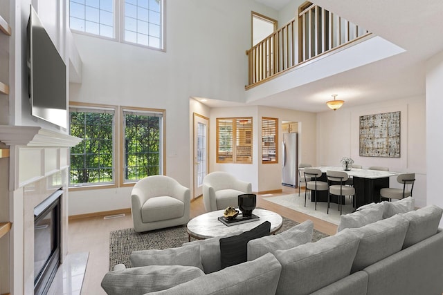 1900 Hunter Hill Rd, Hudson, WI 54016 - living room with healthy amount of natural light, a premium fireplace, light wood finished floors, and a towering ceiling