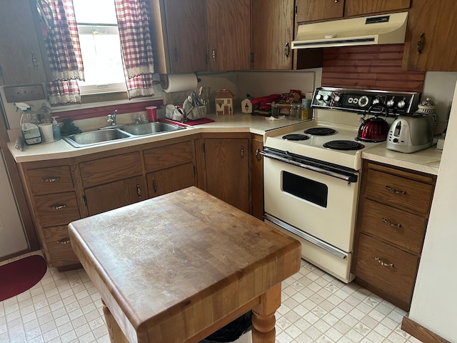 220 Woodman Ave, Dovray, MN 56125 - kitchen with under cabinet range hood, white range with electric cooktop, light countertops, a kitchen island, and light tile patterned flooring