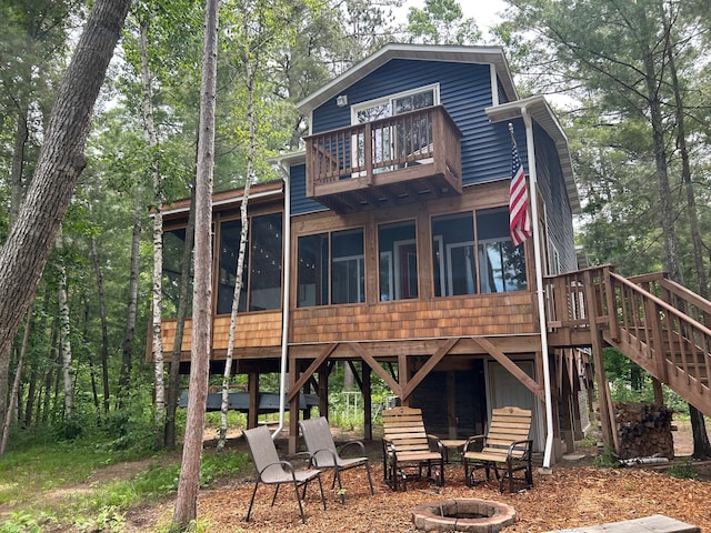 6274 Azalea Rd, Motley Twp, MN 56466 - rear view of property featuring an outdoor fire pit, a sunroom, a balcony, and stairway