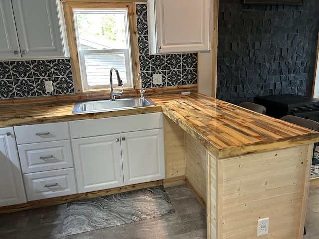 6274 Azalea Rd, Motley Twp, MN 56466 - kitchen featuring butcher block counters, decorative backsplash, white cabinets, and a peninsula