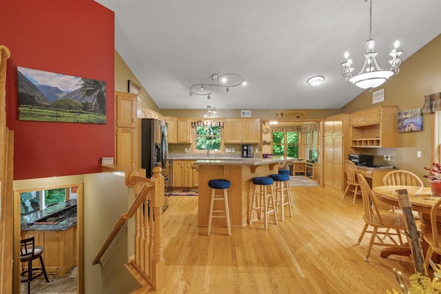 11770 N Meadow Curv, Lindstrom, MN 55045 - kitchen featuring lofted ceiling, light brown cabinets, light wood-type flooring, a breakfast bar area, and light countertops
