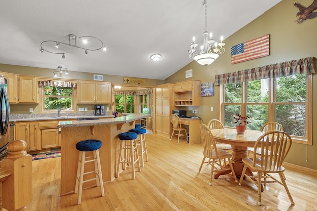 11770 N Meadow Curv, Lindstrom, MN 55045 - kitchen with light brown cabinetry, vaulted ceiling, light wood-style floors, a kitchen breakfast bar, and a chandelier