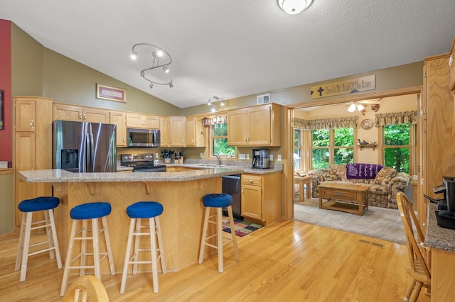 11770 N Meadow Curv, Lindstrom, MN 55045 - kitchen featuring stainless steel appliances, light wood-type flooring, a kitchen breakfast bar, vaulted ceiling, and light brown cabinets