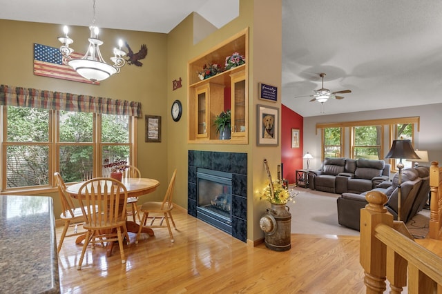 11770 N Meadow Curv, Lindstrom, MN 55045 - dining space with a tiled fireplace, wood finished floors, ceiling fan, and a chandelier