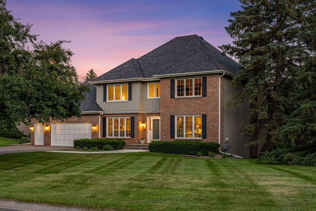 19885 Chartwell Hl, Shorewood, MN 55331 - view of front of house featuring asphalt driveway, brick siding, a front lawn, an attached garage, and a shingled roof