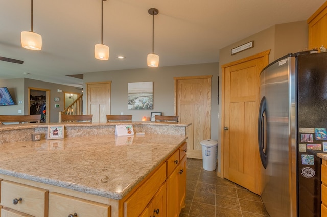 104 Sylla St, River Falls, WI 54022 - kitchen with freestanding refrigerator, light stone counters, dark tile patterned floors, pendant lighting, and recessed lighting