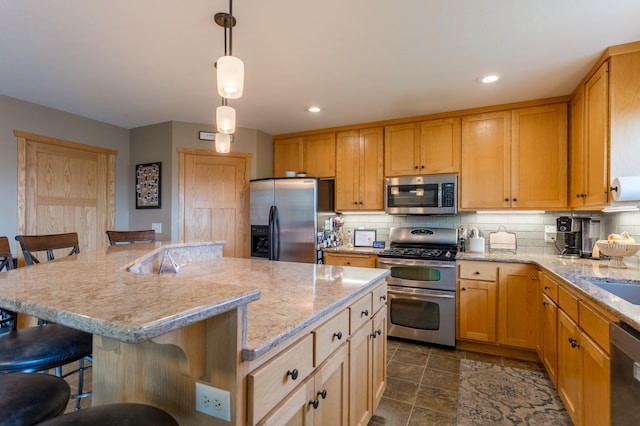 104 Sylla St, River Falls, WI 54022 - kitchen with stainless steel appliances, tasteful backsplash, a kitchen breakfast bar, a center island, and hanging light fixtures