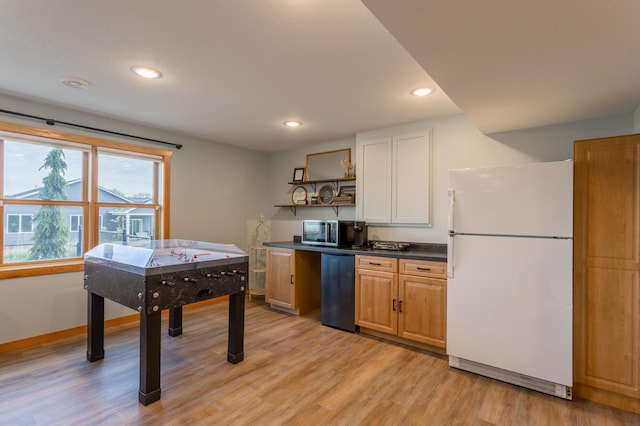 104 Sylla St, River Falls, WI 54022 - kitchen with freestanding refrigerator, stainless steel microwave, open shelves, dark countertops, and light wood finished floors