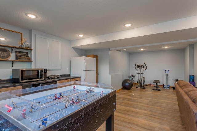 104 Sylla St, River Falls, WI 54022 - kitchen featuring stainless steel microwave, freestanding refrigerator, light wood-style flooring, dark countertops, and open shelves