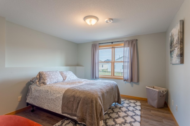104 Sylla St, River Falls, WI 54022 - bedroom featuring wood finished floors and a textured ceiling