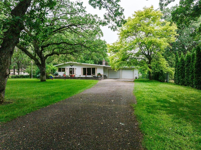 8585 Ilex Pl NW, Rice, MN 56367 - view of front of house featuring driveway, a garage, a chimney, and a front lawn
