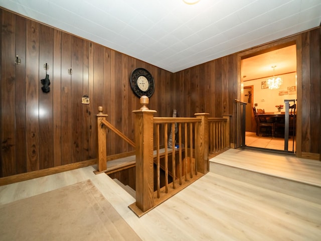 8585 Ilex Pl NW, Rice, MN 56367 - staircase featuring wood finished floors, wooden walls, and a chandelier