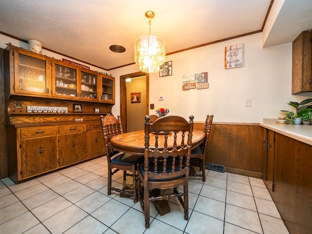 8585 Ilex Pl NW, Rice, MN 56367 - dining room featuring crown molding, a chandelier, light tile patterned floors, and a wainscoted wall