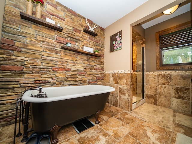 8585 Ilex Pl NW, Rice, MN 56367 - full bath featuring tile walls, a freestanding tub, wainscoting, a walk in shower, and stone finish floors