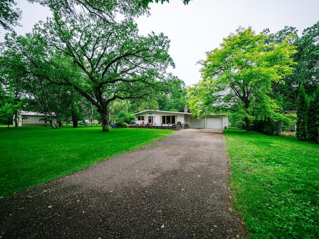 8585 Ilex Pl NW, Rice, MN 56367 - ranch-style house with driveway, a front yard, an attached garage, and a chimney
