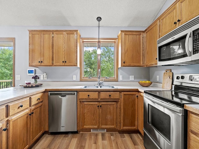 6735 378th St, North Branch, MN 55056 - kitchen featuring stainless steel appliances, light countertops, light wood finished floors, a textured ceiling, and pendant lighting