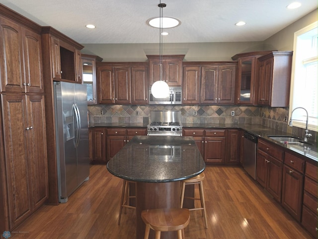 716 Northridge Way W, Fargo, ND 58078 - kitchen featuring appliances with stainless steel finishes, dark wood-style flooring, glass insert cabinets, a breakfast bar area, and decorative backsplash