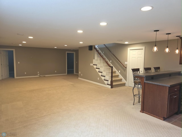 716 Northridge Way W, Fargo, ND 58078 - kitchen with dark countertops, a breakfast bar area, recessed lighting, light colored carpet, and decorative light fixtures