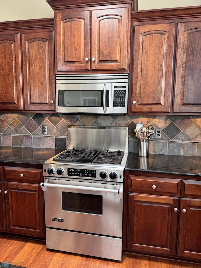 716 Northridge Way W, Fargo, ND 58078 - kitchen with stainless steel appliances, dark stone countertops, tasteful backsplash, and light wood-style flooring