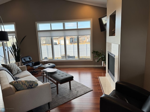 716 Northridge Way W, Fargo, ND 58078 - living room featuring vaulted ceiling, dark wood-type flooring, a tile fireplace, and ornamental molding
