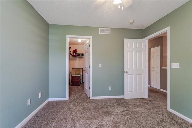 16901 90th Ct N, Maple Grove, MN 55311 - unfurnished bedroom featuring a spacious closet, carpet floors, a closet, a textured ceiling, and ceiling fan