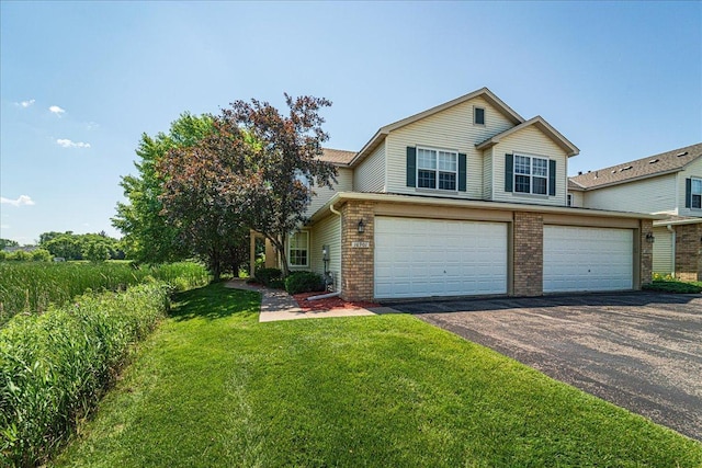 16901 90th Ct N, Maple Grove, MN 55311 - view of front of home with driveway, a front lawn, a garage, and brick siding