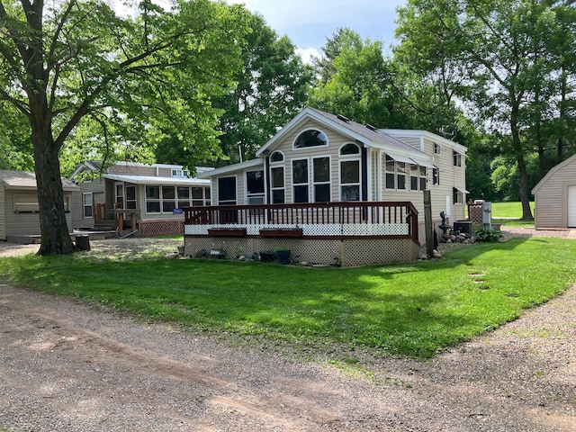 25663 Circle Dr, Garrison, MN 56401 - view of front of property featuring a sunroom, a deck, a front lawn, and an outdoor structure