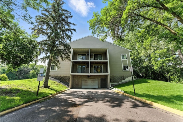 4151 Boone Ave N Unit 210, New Hope, MN 55427 - view of front facade featuring driveway, a balcony, an attached garage, and a front yard