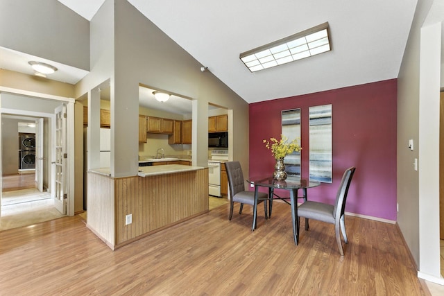 4151 Boone Ave N Unit 210, New Hope, MN 55427 - kitchen featuring white appliances, light wood-style floors, light countertops, a peninsula, and stacked washing machine and dryer