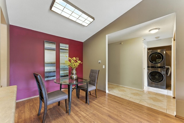 4151 Boone Ave N Unit 210, New Hope, MN 55427 - dining space featuring stacked washer / dryer, wood finished floors, and vaulted ceiling