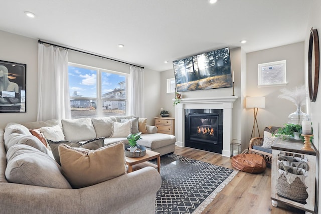 2878 Kama Ave NE, Saint Michael, MN 55376 - living area featuring a glass covered fireplace, wood finished floors, and recessed lighting