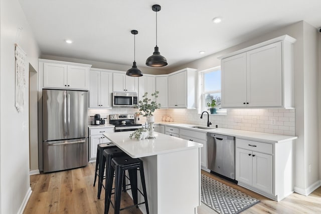2878 Kama Ave NE, Saint Michael, MN 55376 - kitchen with stainless steel appliances, light wood-style flooring, a kitchen breakfast bar, decorative backsplash, and recessed lighting