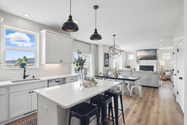2878 Kama Ave NE, Saint Michael, MN 55376 - kitchen with dishwasher, a lit fireplace, plenty of natural light, backsplash, and recessed lighting
